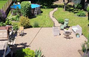 a patio with chairs and a table in a garden at L'étoile du matin in Terville
