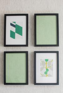 four framed pictures on a wall with green at Wherstead House in Ipswich