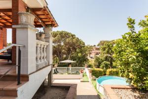 a house with a balcony and a swimming pool at Villa Toro in Maçanet de la Selva