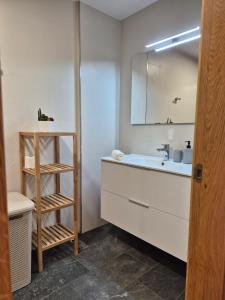 a bathroom with a sink and a mirror at Apartamento Sandy - wifi, ascensor, vistas al Mar,Amplio y Acogedor in Laxe +18 photos