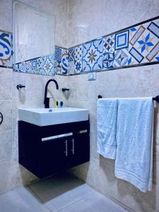 a bathroom with a sink and a mirror and towels at Royal Night Pyramids View Inn in Cairo +44 photos