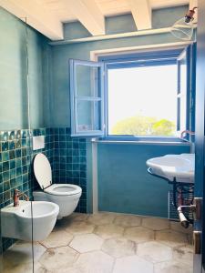 a bathroom with a toilet and a sink and a window at Villa Gioia Agriturismo in Monterosso al Mare
