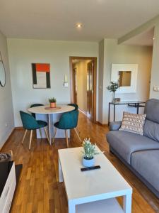 a living room with a couch and a table at Apartamento Sandy - wifi, ascensor, vistas al Mar,Amplio y Acogedor in Laxe
