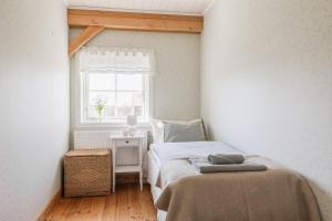 a small bedroom with a bed and a window at Allsta Gård in Bjärtrå