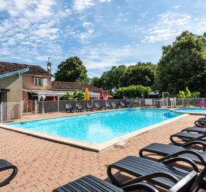 a swimming pool with chaise lounges and chairs at Charmant chalet près d Albi et des vignobles in Rivières