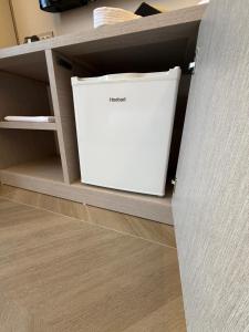 a white refrigerator sitting inside of a cabinet at Rodi Hotel Elbasan in Elbasan