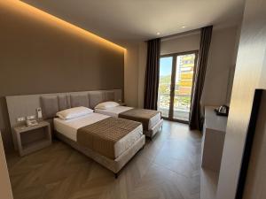 a hotel room with two beds and a window at Rodi Hotel Elbasan in Elbasan