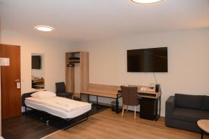 a room with a bed and a desk with a tv at Hotel Hvolsvollur - Central South Iceland in Hvolsvöllur