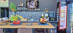 a counter with a table with a bowl of fruit on it at Mustang Boutique Rooms in Oradea