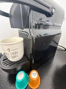 a coffee maker with two different colored cups at Casa da Calma - GUESTHOUSE in Alandroal
