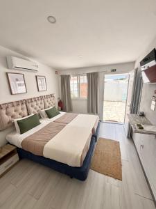 a bedroom with a large bed and a large window at Casa da Calma - GUESTHOUSE in Alandroal