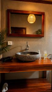 a bathroom with a stone sink and a mirror at Papahan Bali in Sidemen +91 photos
