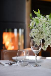 a table with two wine glasses and a vase of flowers at Allsta Gård in Bjärtrå +31 photos