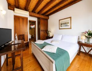 a bedroom with a bed and a desk and a television at Ca' Tessera Venice Airport in Tessera