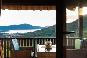 a table and chairs on a balcony with a view at Sunset Holiday Home in Tivat
