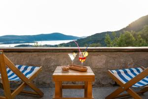 a table with a glass of wine and two chairs at Sunset Holiday Home in Tivat