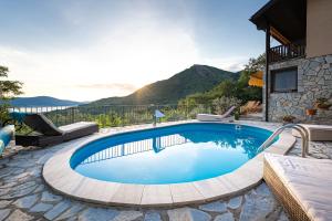 a swimming pool with a view of a mountain at Sunset Holiday Home in Tivat