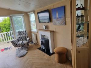 a living room with a fireplace and a tv at The View in Millom