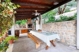 a patio with a table and a stone wall at Sunset Holiday Home in Tivat +37 photos