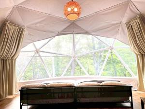 a room with a large window in a tent at Hotel Asobuba白老 in Shiraoi