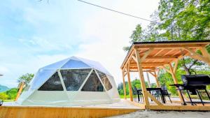 a tent on a wooden deck with a grill at Hotel Asobuba白老 in Shiraoi