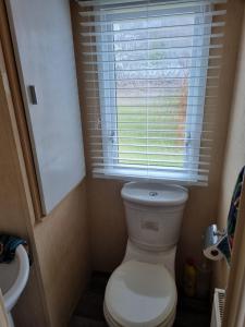 a small bathroom with a toilet and a window at The View in Millom +37 photos
