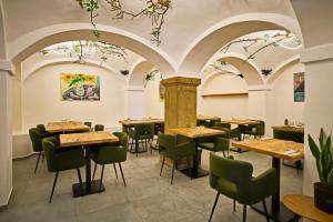 a restaurant with wooden tables and green chairs at Plums Restaurant & Pension in Litomyšl