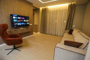 a living room with a couch and a television at Blue Coast Villa -Perla Resort in Lalëz