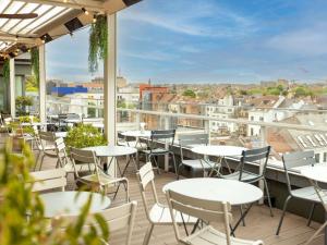 a balcony with tables and chairs and a view of the city at Sofitel Brussels Europe in Brussels