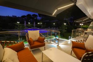 a patio with chairs and tables at night at Blue Coast Villa -Perla Resort in Lalëz
