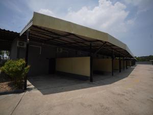 a large building with awning in a parking lot at โรงแรมทูมอร์โรว์แลนด์ อมตะนคร in Ban Khlong Phan Thong