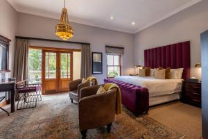 a bedroom with a bed and a desk and chairs at IL Castello Boutique Hotel in Clarens +135 photos