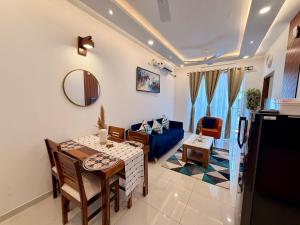 a living room with a table and a blue couch at THE DUIN 1BR Apt Amoret Homes in Chicalim