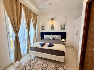 a bedroom with a bed and a large window at THE DUIN 1BR Apt Amoret Homes in Chicalim +10 photos