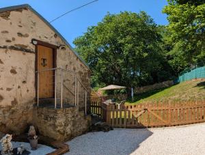 a building with a wooden door and a fence at tillys Cottage in Folles