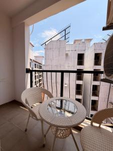 a balcony with a glass table and chairs on a balcony at THE DUIN 1BR Apt Amoret Homes in Chicalim