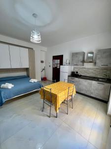 a kitchen with a table and a bed in a room at Affittacamere La bottega del barbiere in Scalea