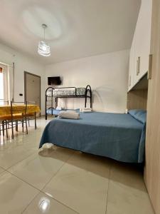 a bedroom with two beds and a dining room at Affittacamere La bottega del barbiere in Scalea