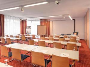 a classroom with tables and chairs and a whiteboard at Mercure Hotel Düsseldorf Ratingen in Ratingen