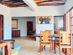 a dining room with wooden tables and chairs at Two Bedroom Private Apartment in Shela, Lamu in Shela