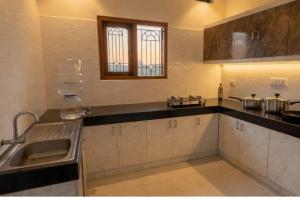 a kitchen with a sink and a counter top at Kattil Madurai in Madurai