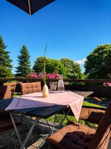 ein Tisch mit zwei Stühlen und einer Vase darauf in der Unterkunft Hotel Daheim in Gehlberg