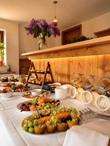 ein Tisch mit vielen Tellern Obst und Gemüse darauf in der Unterkunft Hotel Daheim in Gehlberg