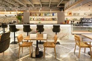 a restaurant with a table and chairs and a bar at Evoras Boutique Hotel in Xirokámbion