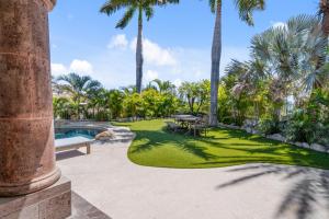 a garden with palm trees and a swimming pool at Palmilla Golf and Beach Villa in San José del Cabo