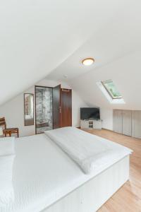 a white bedroom with a large bed and a tv at Casa Diana Confort in Avrig