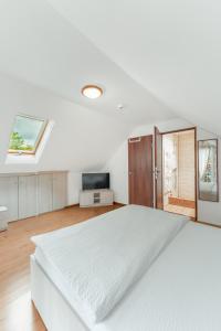 a white bedroom with a bed and a tv at Casa Diana Confort in Avrig