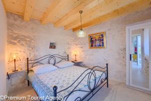 a bedroom with a bed in a stone wall at Hidden Beach Villa Biankura in Smokvica