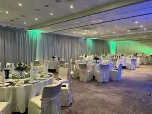 ein Festsaal mit weißen Tischen und weißen Stühlen in der Unterkunft Mercure Tagungs- & Landhotel Krefeld in Krefeld