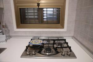 a stove top in a kitchen with a window at Spalti 33 in Trapani